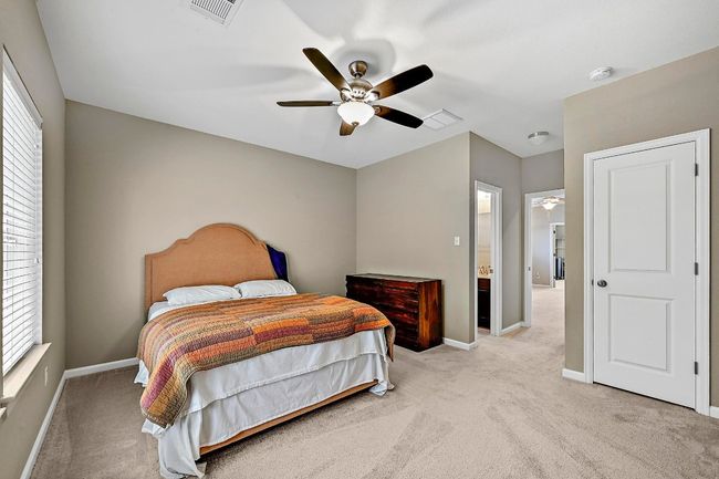 Bedroom with light colored carpet and ceiling fan | Image 32