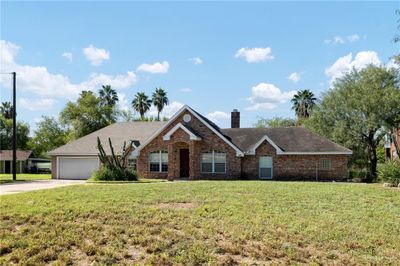 Ranch-style home featuring a garage and a front lawn | Image 1