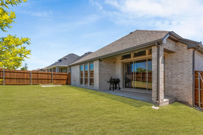 Back of property featuring brick siding, roof with shingles, and a patio | Image 31