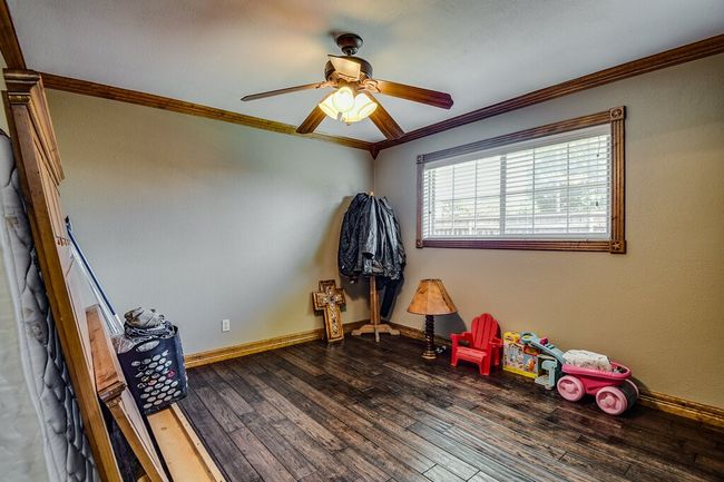 Playroom with ornamental molding, a ceiling fan, and wood finished floors | Image 18