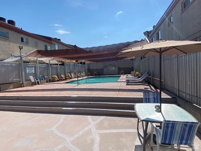 Community pool with a fenced backyard and a patio area | Image 16
