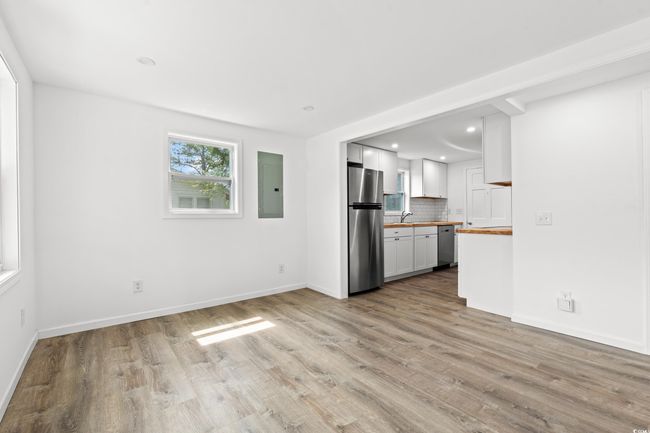 Unfurnished living room featuring electric panel, light wood-style floors, baseboards, and recessed lighting | Image 6