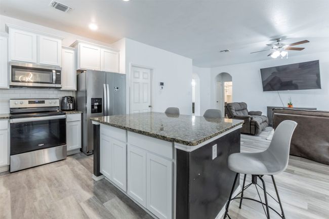 Kitchen with visible vents, arched walkways, light wood finished floors, and appliances with stainless steel finishes | Image 6