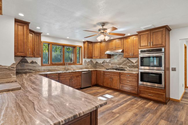 Kitchen with marble counters and backsplash | Image 19