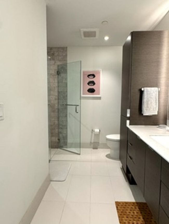 Full bathroom featuring a shower stall, toilet, tile patterned flooring, vanity, and baseboards | Image 14