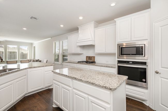 Kitchen with visible vents, a sink, stainless steel appliances, custom range hood, and plenty of natural light | Image 9