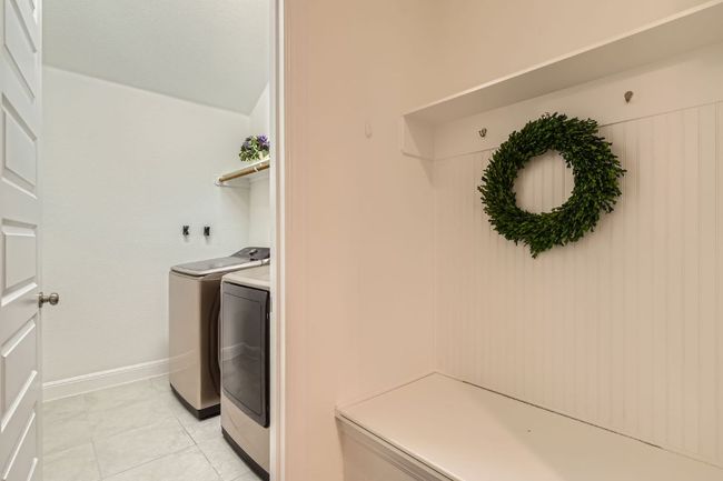 Laundry room with washing machine and dryer and light tile patterned flooring | Image 25