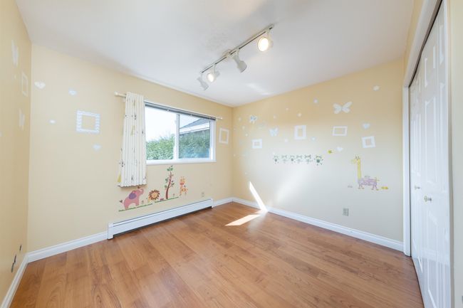 Spare room featuring baseboards, track lighting, baseboard heating, and light wood finished floors | Image 25