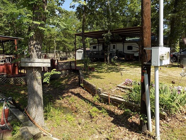 View of yard to other covered RV space Only!RV NOT included in this photo. | Image 11