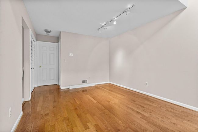 Spare room featuring rail lighting, baseboards, and light wood-type flooring | Image 11