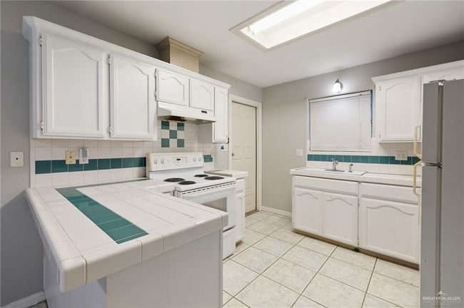 Kitchen featuring Tile Countertops and Back Splashes, White Appliances | Image 4