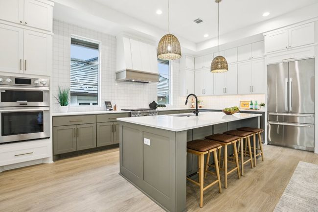 A chef’s dream kitchen, equipped with a massive island, double ovens, and custom cabinetry. | Image 16