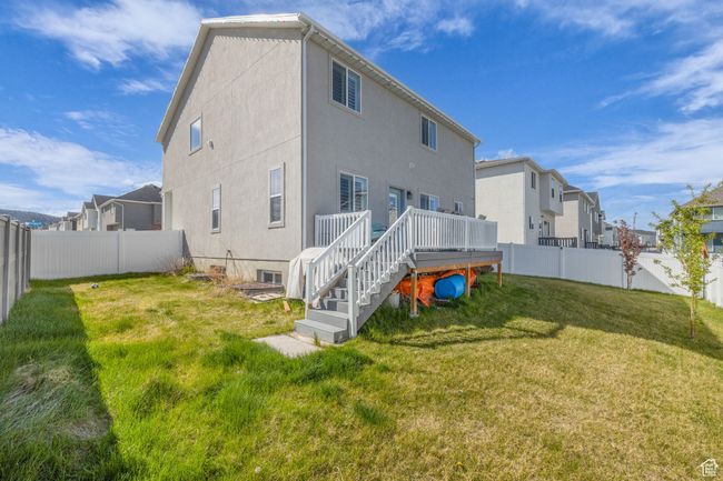 Back of house featuring a residential view, a fenced backyard, stairway, a deck, and a yard | Image 30