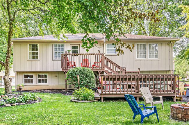 rear view of house featuring an outdoor fire pit, a deck, and a yard | Image 28
