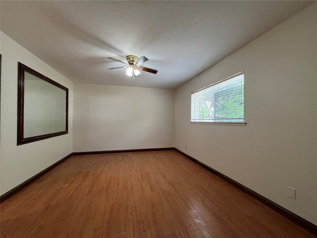 Empty room featuring ceiling fan, wood finished floors, and baseboards | Image 9
