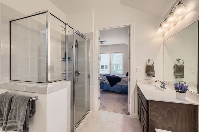 Full bathroom with vanity, tile patterned floors, a shower stall, connected bathroom, and vaulted ceiling | Image 18