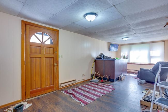 3rd unit living room, hardwood / wood-style flooring, baseboard heating, and a drop ceiling | Image 39