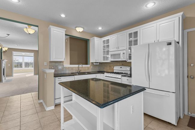 Center island with granite countertop provides a great place to bake, and prepare meals. | Image 17