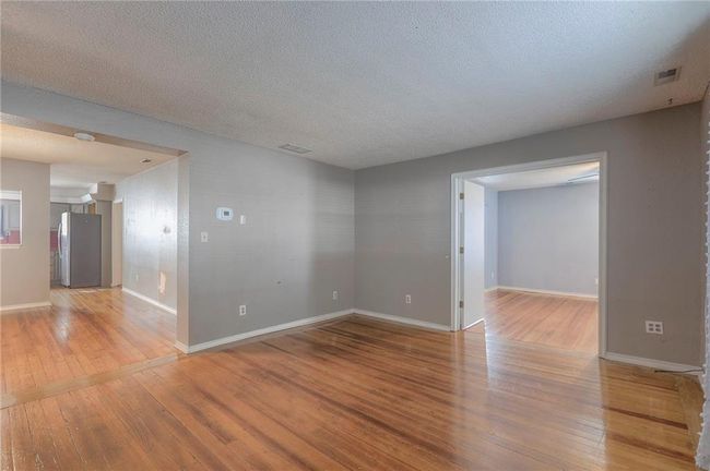 Unfurnished room with light wood-style flooring, a textured ceiling, and visible vents | Image 38