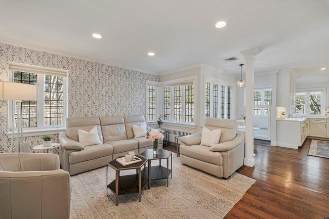 Family room is connected to the Chef's kitchen with recessed lighting, wallpapered walls light streaming in. | Image 7