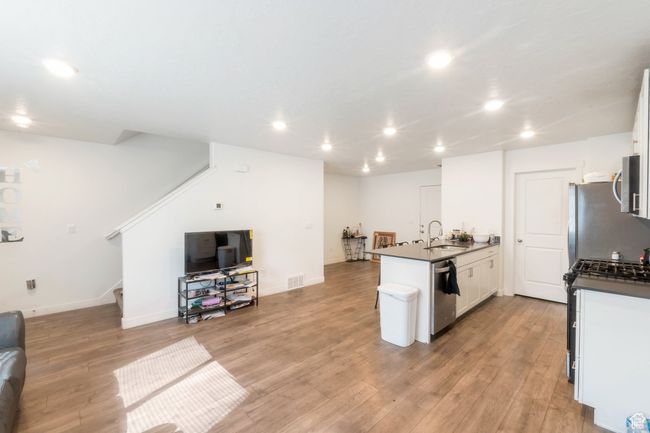 Kitchen with open floor plan, dark countertops, recessed lighting, a peninsula, and appliances with stainless steel finishes | Image 5