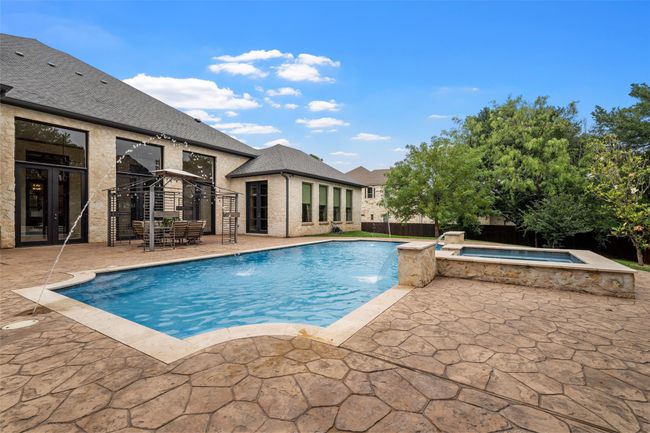 View of swimming pool featuring a fenced in pool, fence, an in ground hot tub, and a patio area | Image 38