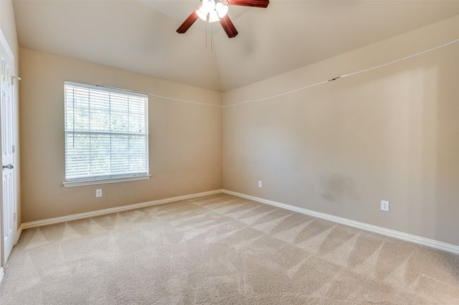 Carpeted upstairs bedroom with a ceiling fan and lofted ceiling | Image 14