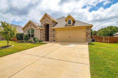 View of front of property with central air condition unit, a front yard, and a garage | Image 2