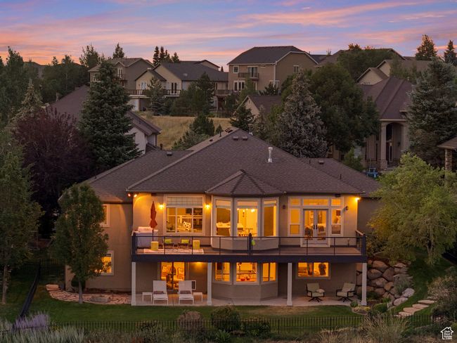 Back of property with a patio, a residential view, stucco siding, and a shingled roof | Image 5