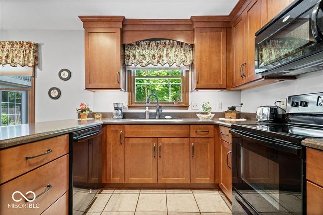kitchen featuring black appliances and brown cabinets | Image 13