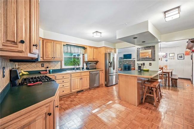 Spacious kitchen w/ peninsula, gas stove, stainless dishwasher & refrigerator. | Image 14