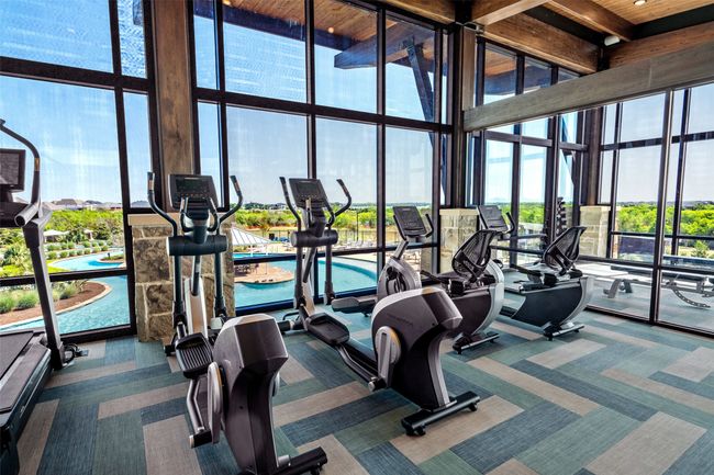 Exercise room featuring carpet flooring, a towering ceiling, and floor to ceiling windows | Image 23