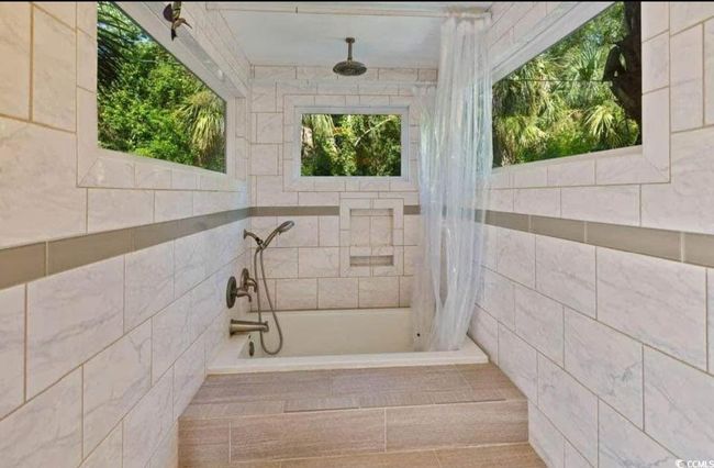 Bathroom featuring tiled shower and a bath | Image 15