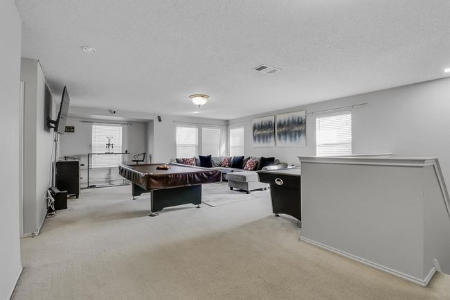 Playroom with a textured ceiling, billiards, visible vents, and light carpet | Image 10