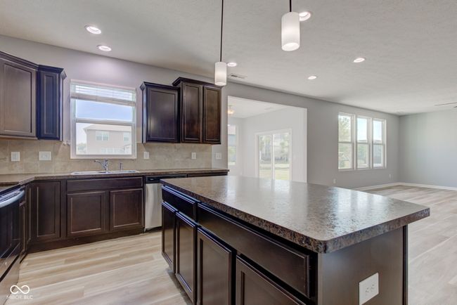 kitchen with stainless steel appliances, dark countertops, light wood-style flooring, tasteful backsplash, and recessed lighting | Image 12