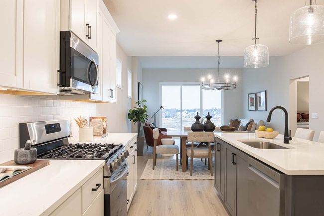 LG appliances, ample counter space, and a large island make cooking and entertaining a joy. The thoughtful layout ensures everything is within reach. Photos are from previous built home; options and features will vary. | Image 4