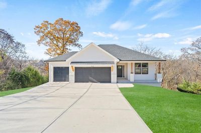 View of front of property with a garage, a front yard, and covered porch | Image 1