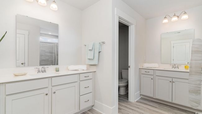 Full bathroom with vanity, wood finished floors, toilet, and a tile shower | Image 21