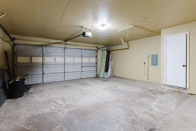 Garage featuring electric panel and a garage door opener | Image 26