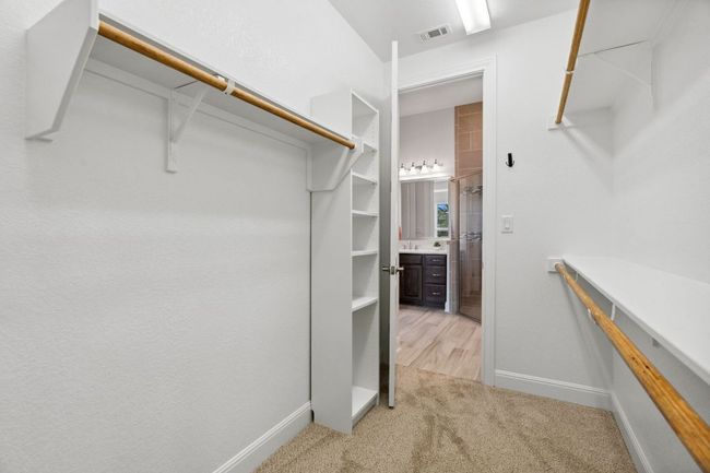 Walk in closet with light colored carpet and visible vents | Image 25