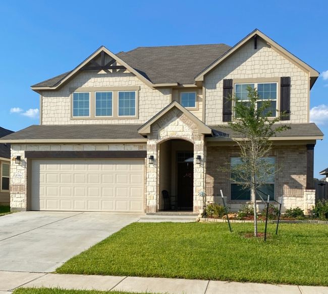Craftsman-style house featuring a garage, roof with shingles, stone siding, a front lawn, and concrete driveway | Image 26