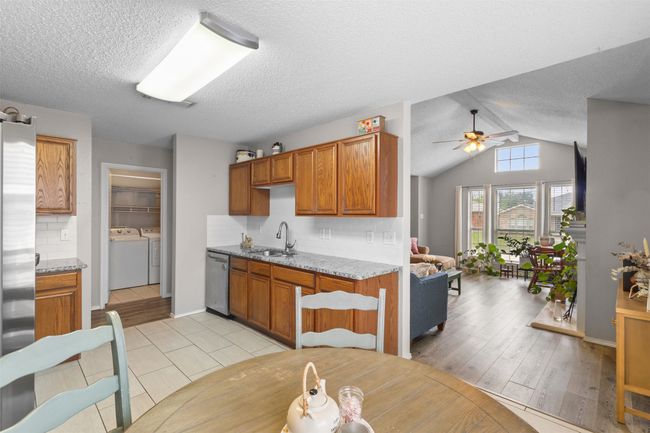 Kitchen with separate washer and dryer, appliances with stainless steel finishes, ceiling fan, decorative backsplash, and a textured ceiling | Image 16
