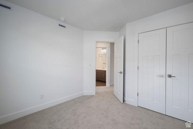 Unfurnished bedroom featuring visible vents, light carpet, baseboards, and a closet | Image 15