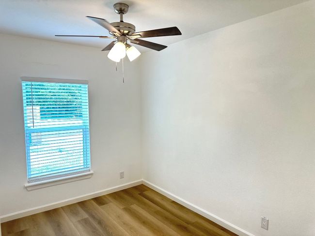 Spare room featuring baseboards, wood finished floors, and a ceiling fan | Image 14