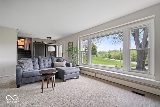 carpeted living area with a baseboard heating unit | Image 5