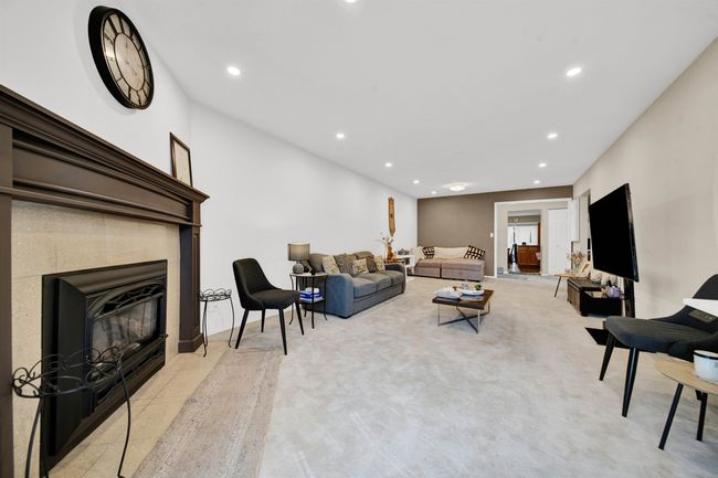 Living room with carpet floors, recessed lighting, and a glass covered fireplace | Image 10