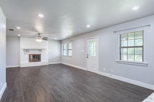 Unfurnished living room with a ceiling fan, visible vents, recessed lighting, and dark wood finished floors | Image 9