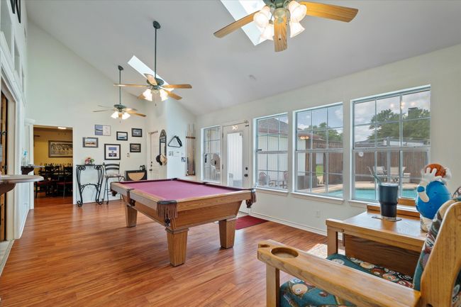 Playroom with a ceiling fan, billiards, healthy amount of natural light, light wood finished floors, and high vaulted ceiling | Image 12