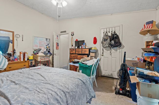 Bedroom with carpet flooring, a textured ceiling, and crown molding | Image 22