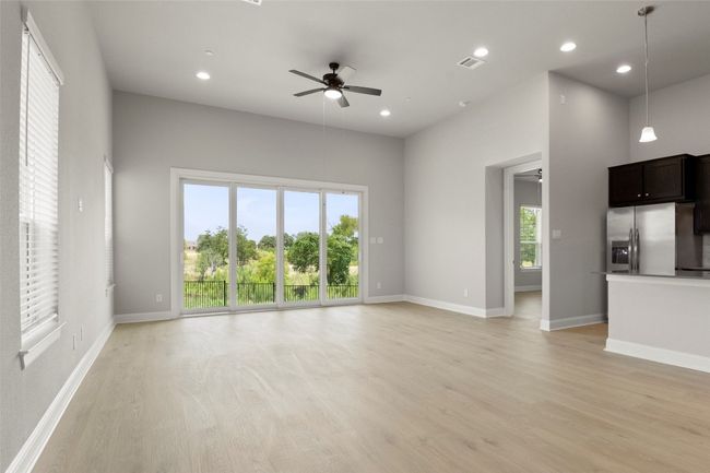 Unfurnished living room with light wood-style flooring, a ceiling fan, and recessed lighting | Image 10